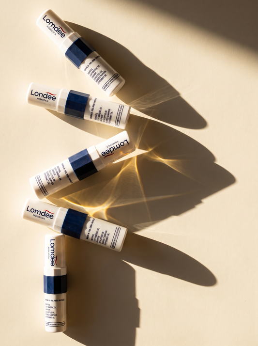 Fünf Lomdee Nosesticks liegen im Sonnenlicht auf beigem Untergrund